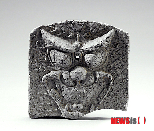 【대전=뉴시스】박희송 기자 = 문화재청 국립문화재연구소는 24일 기와·전돌이 약 2000년 동안 지붕 등 건축물 장식용으로 사용돼 온 가운데 각 시대별 문양 소개, 문양 변천의 큰 흐름을 쉽게 파악할 수 있는 '우리나라 전통 무늬 6 와전'을 발간했다. 사진은 '우리나라 전통 무늬 6 와전'에 소개된 귀면문마루기와. 2013.12.24. (사진=문화재청 제공)&nbsp; photo@newsis.com 