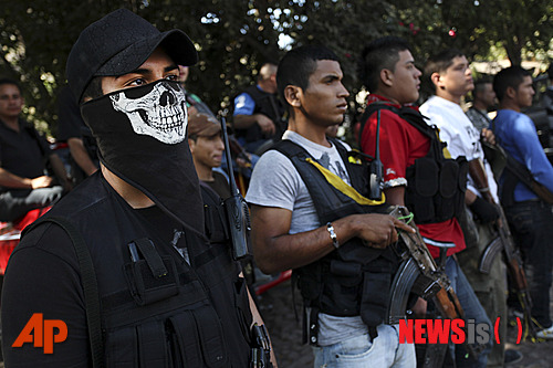 【안투네즈(멕시코)=AP/뉴시스】멕시코 미초아칸주 자경단 소속의 대원들이 15일 안투네즈에서 열린 동료 마리오 페레스의 장례식을 위해 묘지에 모여 있다. 정부가 조직해 마약 조직과 싸워왔던 이들은 전날 정부군의 무장 해제 명령을 어기고&nbsp; 총격전을 벌이며 저항 끝에 3명의 대원이 숨졌는데도 무기 반납을 거부하고 있다. 2014.1.16&nbsp;&nbsp; 