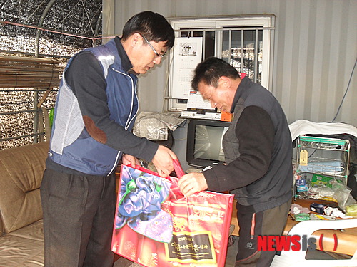 【통영=뉴시스】신정철 기자 = 이영태(왼쪽) 전국공무원노조 통영시지부장은 29일 공무원들이 동전 모으기 운동으로 조성한 60만원을 경제적으로 어려움을 겪고 있는 위기가정에 전달하고 있다.2014.01.29(사진=전공노통영시지부 제공)&nbsp; photo@newsis.com 