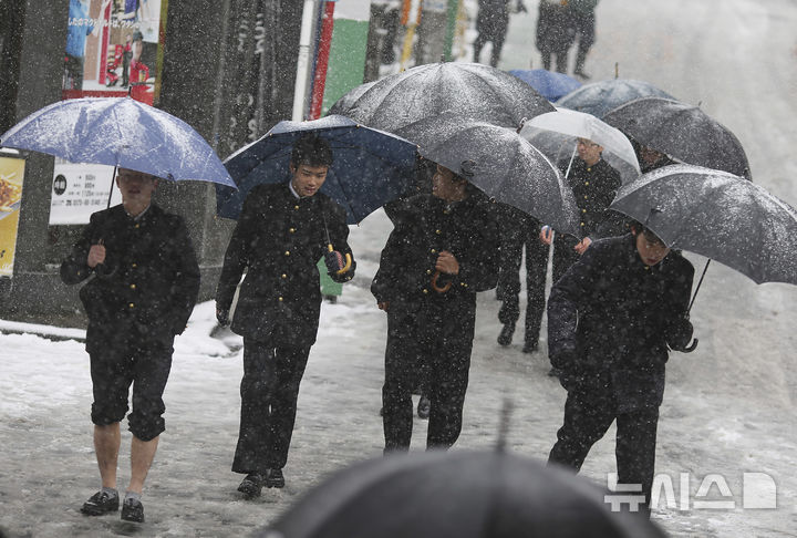 [요코하마=AP/뉴시스]도쿄 인근 요코하마에서 교복을 입은 학생들이 눈 덮인 길을 걷고 있다. 2024.02.08.