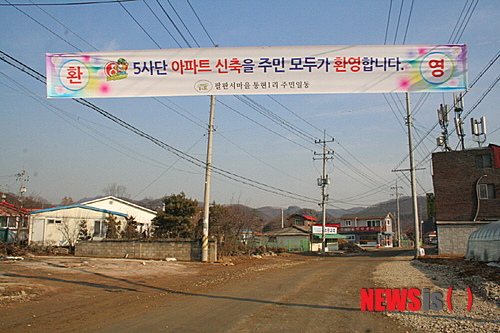【연천=뉴시스】김칠호 기자= 경기도 연천군 연천읍 팔판서마을 통현1리 입구에 10일 “5사단아파트 신축을 주민 모두가 환영합니다”라는 현수막이 걸려 있다. 이곳에는 1340가구의 군인 아파트가 민간투자사업으로 건설된다. 2014.02.11 (사진=연천군 제공)&nbsp; seven5@newsis.com 