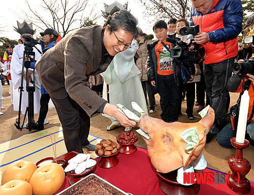 【서울=뉴시스】박문호 기자 = 정월대보름을 하루 앞둔 13일 오후 서울 종로구 삼청로 국립민속박물관에서 서울시 무형문화재 3호인 정월대보름 맞이 '송파다리밟기'가 펼쳐진 가운데 천진기 국립민속박물관장이 복돼지에 돈을 꼽으며 복을 빌고 있다. 다리밟기는 정월 대보름에 하는 놀이로 자기 나이만큼 개울가 다리를 밟으면 다리에 병이 나지 않고, 모든 재앙을 물리칠 뿐 아니라 복을 불러들인다는 민간신앙적 풍속에서 유래됐다. 2014.02.13. go2@newsis.com