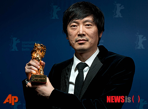  【 베를린=AP/뉴시스】15일 베를린 영화제에서 '백일염화(白日焰火)'로 대상을 받은 디아오 이난 감독이 황금트로피를 들어 보이고 있다.