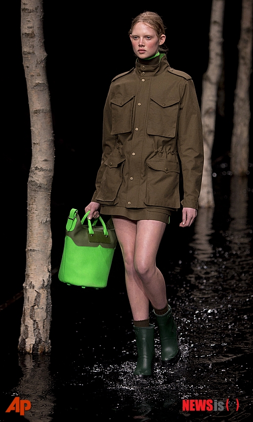 【런던=AP/뉴시스】런던 패션위크의 주말 헌터 쇼에서 15일(현지시간) 헌터 오리지널 재킷과 전통의 고무장화를 착용한 모델이 물에 젖은 런웨이를 철벅 거리며 걷고 있다. 2014.02.16&nbsp; 