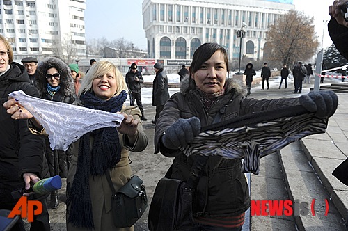 【알마티(카자흐스탄)=AP/뉴시스】지난 16일(현지시간) 카자흐스탄 제2 도시인 알마티에서 여성 시위자들이 속옷을 들고 시위를 벌이고 있다. 카자흐스탄 여성들이 알마티와 수도 아스타나에서 레이스 달린 속옷을 입지 못하도록 한 당국의 정책에 항의하는 시위를 벌이다 체포됐다 풀려난 것으로 전해졌다. 러시아가 주도하고 카자흐스탄, 벨라루스가 참여하고 있는 관세동맹은 오는 7월부터 레이스가 달린 속옷의 생산·수입·판매를 전면 금지한다고 밝혔다. 2014.02.18
