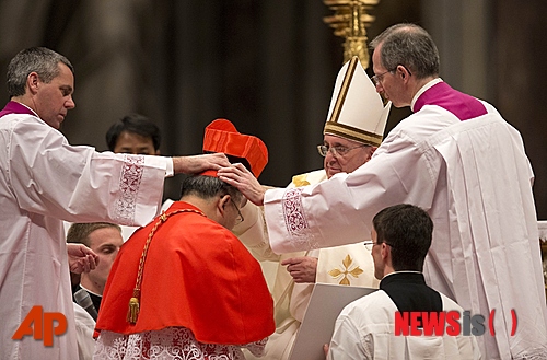 【바티칸=AP/뉴시스】한국 염수정 대주교가 22일(현지시각) 이태리 로마 바티칸 성 베드로 대성당에서 프랜시스 교황으로 부터 추기경 빨간색 비레타를 받으며 서임식이 진행되고 있다. 염 대주교를 포함해 이날 새로운 추기경 19명이 서임 됐다. 