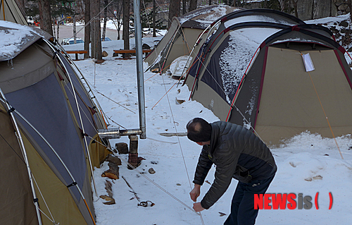 【태백=뉴시스】홍춘봉 기자 = 강원 태백시 태백산도립공원의 야영장이 한겨울에도 인기를 얻고 있다. 사진은 지난 7일 오후 태백산 당골 야영장에 한 텐트족이 텐트 줄을 점검하고 있는 모습. 2014.03.09.&nbsp; casinohong@newsis.com 