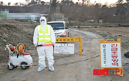 【증평=뉴시스】강신욱 기자 = 21일 조류 인플루엔자 양성 반응이 나온 충북 증평군 도안면 화성리 한 닭 사육농장 입구를 가축위생방역지원본부 관계자가 통제하고 있다. 2014.03.21.&nbsp;&nbsp; ksw64@newsis.com 