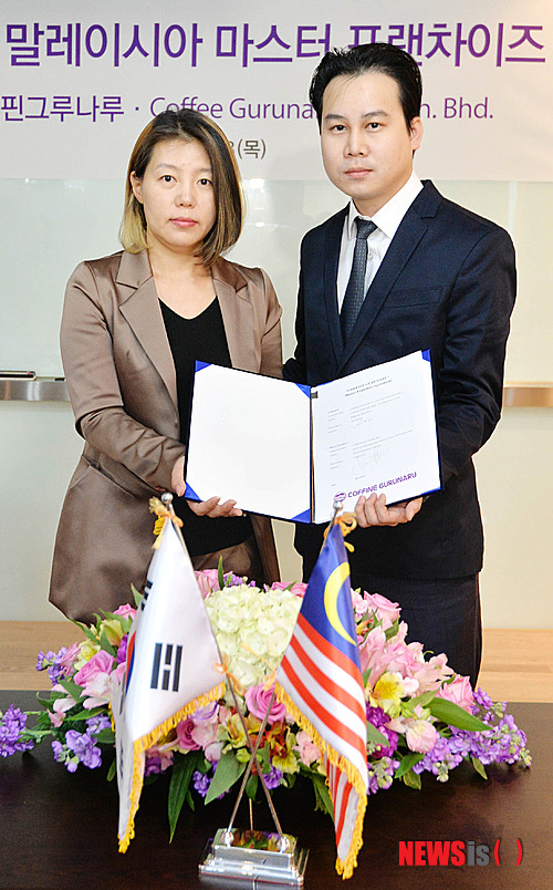 【서울=뉴시스】박문호 기자 = 3일 오전 강남구 봉은사로 커핀그루나루 회의실에서 열린 ‘커핀그루나루-말레이시아 마스터 프랜차이즈 체결식’에서 김은희(왼쪽) 커핀그루나루 대표와 말레이시아 체결자 로렌트로우가 협약서를 들고 포즈를 취하고 있다. 2014.04.03. go2@newsis.com