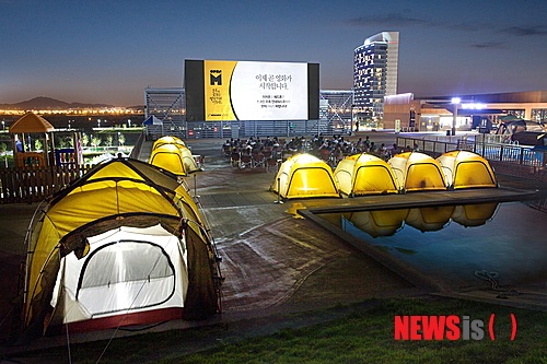 【서울=뉴시스】박영주 기자 = 멀티플렉스 영화관 메가박스가 야외 스크린으로 즐기는 캠핑 시네마 오픈M을 재개했다.&nbsp; 텐트 안이나 캠핑 의자에 앉아 영화 감상이 가능한 야외 영화관이다. 바비큐, 즉석구이 등 다양한 그릴 메뉴가 제공된다. 지난해 6월 일산 백석점에 처음 개관한 후, 일산 원마운트에 2호점을 오픈했다.&nbsp; 매주 금, 토, 일요일 3일간 연중 운영한다. 고양 국제꽃박람회, 어린이날, 월드컵 시즌, 여름 휴가, 추석 등에 맞춰 특별 운영할 예정이다.&nbsp; 메가박스는 4월 한 달 동안 소시지, 차슈, 스테이크 등 바비큐 음식과 팝콘을 무제한으로 제공하는 패키지를 운영한다. 일반석은 성인 2만원, 청소년 1만5000원이며 스위트 텐트(2인기준) 4만5000원, 패밀리 텐트(4인기준)는 7만5000원에 이용할 수 있다. www.megabox.co.kr&nbsp; gogogirl@newsis.com