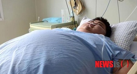 【서울=뉴시스】몸무게가 300㎏에 달하던 중국 최고 비만 남성 쑨량(孫亮·22)이 입원치료를 받던 도중 비만으로 인한 심폐기능 저하로 지난 20일 숨진 것으로 전해졌다. 쑨씨가 생전에 산둥(山東)성 르자오(日照)의 한 병원에서 치료받고 있던 모습. (사진출처: 중국 건강망) 