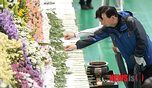 【대구=뉴시스】주기철 기자 = 세월호 여객선 침몰 사고 13일째인 28일 오전 대구 두류공원 내 안병근 올림픽기념 유도관에 마련된 세월호 침몰 희생자 합동분향소를 찾은 시민들이 희생자들을 위해 헌화를 하고 있다. 2014.04.28. joo4620@newsis.com