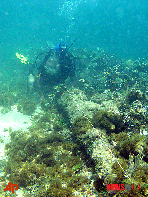 【포르토프랭스=AP/뉴시스】2003년 5월 사진으로 다이버가 아이티 북쪽 해안 속 바닥돌 더미​​ 옆에 있는 롬바르드 대포의 길이를 재고 있다. 미국 심해 탐험가 배리 클리포드가 이곳이 난파한 크리스토퍼 콜럼버스의 산타마리아호 잔해가 있는 곳일 수 있다고 주장하고 있다. 그는 스페인산 혹은 포르투갈산 바닥돌들, 15세기 제작된 대포를 이 난파선이 1492년 성탄절에 좌초한 산타마리아호의 잔해라는 증거라고 밝혔다. 15세기 제작된 대포는 처음 조사에서 있었으나 이후 사라졌다. 2014.05.14