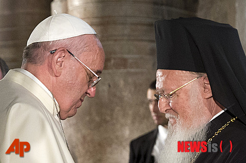  【예루살렘 =AP/뉴시스】프란치스코 로마교황이 25일 예루살렘 성묘교회에서 동방정교의 수장인 바르톨로메오스 1세의 손을 잡고 있다. 이들 기독교의 두 지도자는 예수가 십자가형을 당해 묻혔다 부활했다는 곳에 세워진 교회에서 동서 교회의 단합을 위해 기도했다.