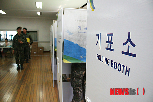 【춘천=뉴시스】박혜림 기자 = 6·4 전국동시지방선거 사전투표 첫날인 30일 이른 아침부터 강원 춘천시 퇴계동 사전투표소를 찾은 육군 장병들이 기표소 앞에 늘어서 있다. 2014.05.30. hlpark@newsis.com