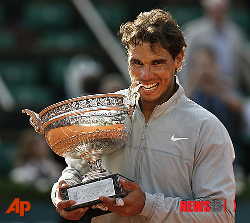 【파리=AP/뉴시스】라파엘 나달(28·스페인·세계랭킹 1위)이 8일(한국시간) 프랑스 파리의 스타드 롤랑가로에서 열린 프랑스오픈 테니스대회 남자 단식 결승에서 세계랭킹 2위 노박 조코비치(27·세르비아)를 3-1(3-6 7-5 6-2 6-4)로 꺾고 우승한 후 트로피를 깨물고 있다.