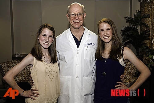 【휴스턴=AP/뉴시스】세상에 태어난 지 10개월 때 분리수술을 성공적으로 받은 미국 샴쌍둥이 자매가 어엿한 18세 숙녀로 성장해 잔잔한 감동을 주고 있다. 미국 텍사스주 휴스턴에 사는 에밀리와 케이틀린 코플랜드 자매는 지난 10일(현지시간) 성인을 뜻하는 18세 생일을 맞았다. 사진은 이들 자매가 1996년 분리수술을 집도한 메모리얼 허먼 병원의 게빈 랠리 교수와 함께 있는 모습. 2014.6.15