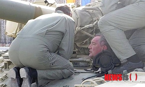 【서울=뉴시스】러시아의 방위산업을 책임지고 있는 드미트리 로고진 러시아 부총리가 지난 12일(현지시간) 비만 체형으로 탱크에 탔다 갇혀 굴욕당해 화제가 됐다. 사진은 지난 12일 로고진 부총리가 러시아 군 T-90A 탱크 조종석에 앉아보려 하다가 비만인 체형 때문에 탱크 입구에 그대로 걸린 모습. (사진출처:러시아 워트뉴스(WOT-news)) 