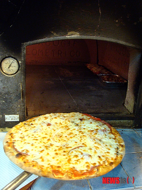 【부천=뉴시스】박영주 기자 = 시야가 탁 트인 조리대에 밀가루가 뿌려진다. 24시간 잘 숙성된 반죽이 밀가루와 뒤섞인다. 손으로 반죽을 다듬으며 평평하게 만든다. 그 위에 토마토소스를 바르고 각종 토핑을 올린 다음 모차렐라 치즈를 뿌린다. 뜨겁게 달궈진 동굴 속으로 들어간 피자는 먹음직스러운 색깔로 단장하고 등장한다.&nbsp; gogogirl@newsis.com&nbsp; 
