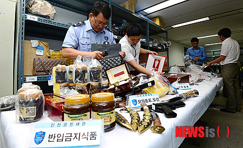 [서울=뉴시스]김진아 기자 = 인천공항세관 직원들이  인천 중구 운서동 인천공항세관 체화창고에서 고가의 해외유명상표 가방, 시계 등 면세범위 초과로 유치된 물품과 총포 및 도검, 히말라야 석청 등 반임금지물품을 감정하고 있다. 2023.06.11. bluesoda@newsis.com