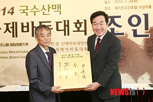 【서울=뉴시스】재단법인 한국기원과 '국수(國手)의 고향' 전라남도 재단법인 한국기원과 전라남도, 강진군(김인 9단), 영암군(조훈현 9단), 신안군(이세돌 9단)이 8월 9~11일 전남 3개군을 순회하면서 '2014 국수산맥 국제바둑대회'를 연다. 사진은 29일 서울 중구 소공동 웨스틴 조선호텔에서 열린 조인식에서 김인 9단(왼쪽)이 이낙연 전남지사에게 국수 3인의 휘호반을 증정하는 모습.(사진제공=한국기원)&nbsp; 