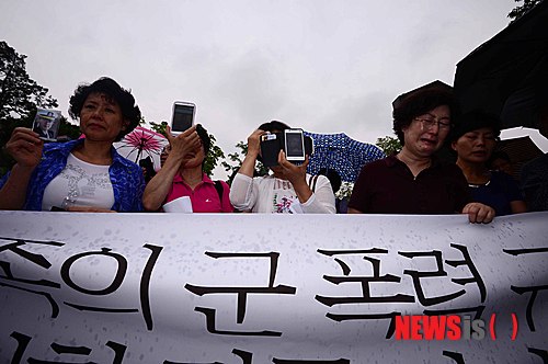 【서울=뉴시스】전신 기자 = 윤 일병 등 군대 내 가혹행위로 인한 사망사건이 잇따르면서 군 폭력 문제가 심화되고 있는 6일 오전 서울 용산구 국방부 앞에서 열린 군 폭력 규탄 및 사망 군인 명예회복 촉구 기자회견에서 군 사망사고 피해 유족들이 희생자의 사진을 들어보이고 있다. 2014.08.06.  photo1006@newsis.com 