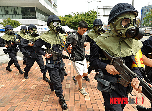 【서울=뉴시스】박문호 기자 = 20일 오후 서울 강서구 공항대로 서울도시가스 본사에서 열린 ‘제395차 민방위의 날, 민방공 대피훈련’에서 방독면을 쓴 대테러 요원들이 테러범을 잡아 이송하고 있다.&nbsp;&nbsp; 이번 민방위훈련은 서울의 주요시설과 기반시설이 적의 공격에 노출됐을 때를 가정한 시민 대피 훈련으로, 을지연습과 연계해 실시됐다. 2014.08.20.&nbsp;&nbsp; go2@newsis.com 