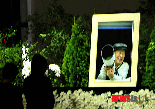 【안성=뉴시스】이정하 기자 = 기독교복음침례회(구원파)의 본거지로 알려진 경기 안성 금수원이 30일 금수원 내 대강당에 차례진 유병언 전 세모그룹 회장의 장례식장 내부를 공개했다. 제단 중앙에 놓인 유 전 회장의 영정은 유가족의 뜻에 따라 카메라를 들고 환하게 웃고 있는 유 전 회장의 사진을 사용한 것으로 전해졌다. 2014.08.30 (사진=금수원 제공)&nbsp; photo@newsis.com