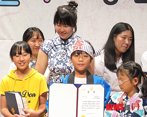 【단양=뉴시스】이성기 기자 = 충북도교육청 주최로 지난 2일 충북학생교육문화원에서 열린 충북 다문화 학생 '이중 언어 말하기 대회'에서 대상을 받은 단양 가곡초 대곡분교 김새얼(5학년·가운데) 학생이 상장을 들어보이고 있다.2014.09.03(사진=단양교육지원청 제공) sklee@newsis.com