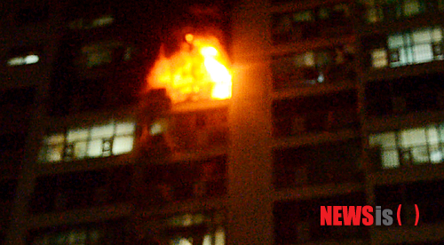 【광주=뉴시스】배동민 기자 = 13일 오후 11시53분께 광주 서구 쌍촌동 한 아파트 12층 민모(48)씨의 집에서 불이 나 거실 등 80㎡을 태우고 119에 의해 20여분 만에 진화됐다. 이 불로 민씨와 민씨의 아내(41)가 3도 화상을 입고 주민 10명이 연기를 들이마셔 병원으로 옮겨져 치료를 받고 있다. 이날 화재는 부부싸움을 한 뒤 홧김에 민씨가 집에 인화성 물질을 뿌린 뒤 불을 질러 일어난 것으로 조사됐다. 사진은 화재로 타고 있는 아파트 모습. 2014.09.14. (사진=광주 서부소방서 제공)&nbsp;&nbsp; photo@newsis.com 