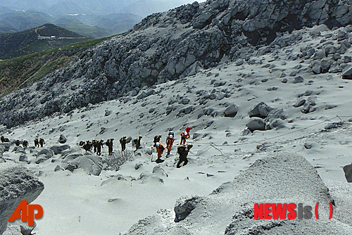 【도쿄=AP/뉴시스】일본 나고야(名古屋)시 소방대(주황색 옷차림)와 일본 자위대 대원들이 9월28일 중부 온타케(御嶽) 화산에서 구조작업을 위해 화산재에 덮인 산등성이를 따라 분화구로 올라가고 있다. 이틀 후 활발해진 화산활동에 다시 폭발이 일어날 것이라는 우려가 제기되면서 구조대가 분화구 인근에서 벌인 수색 작업을 일시 중단했다. 이 화산이 지난 27일 처음 분출한 이후 수십 명이 사망했다. 2014.10.01