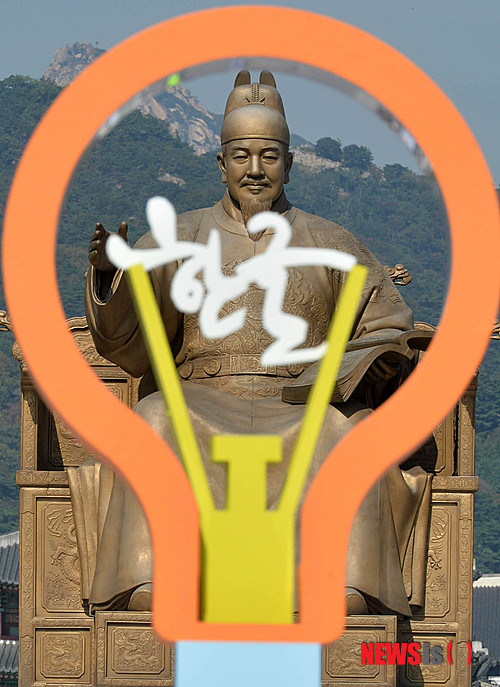 【서울=뉴시스】박문호 기자 = 제568돌 한글날을 하루 앞둔 8일 오후 서울 종로구 세종대로 광화문 광장에 설치된 '한글' 조형물 뒤로 세종대왕이 인자한 미소를 짓고 있다. 2014.10.08.&nbsp; go2@newsis.com