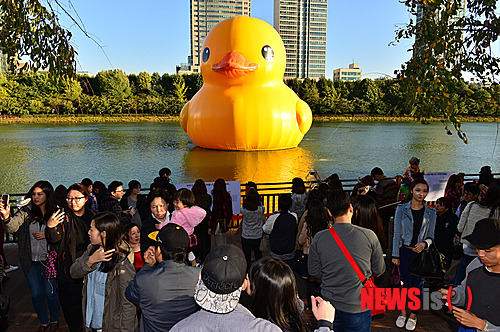 【서울=뉴시스】조종원 기자 = 16일 오후 서울 송파구 석촌호수에서 시민들이 1톤짜리 초대형 고무오리 '러버덕'을 배경으로 기념촬영을 하고 있다. 2014.10.16.&nbsp; choswat@newsis.com