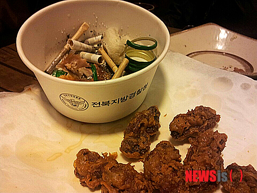 【전주=뉴시스】윤난슬 기자 = 26일 오후 전북 전주시 송천동 먹자골목 한 통닭집에서 담배재털이로 전북경찰청 이름과 심벌이 찍힌 일회용 용기를 제공하고 있다. 이 용기는 직원 가족들의 상을 당했을 때 제공되는 것이다. 2014.10.29. (사진=시민제공) photo@newsis.com