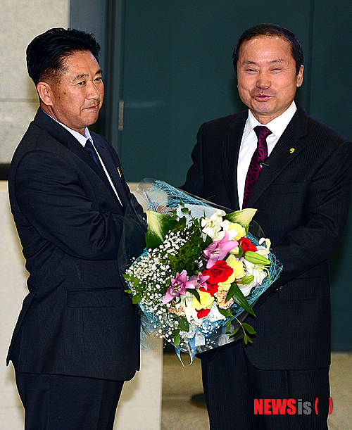 【인천공항=뉴시스】조성봉 기자 = 북한 4.25체육단의 유소년 축구단이 2일 저녁 인천국제공항을 통해 입국한 가운데 김규선(오른쪽) 연천군수가 북한 문웅 단장에게 꽃다발을 전달하고 있다. 북한 유소년 축구단의 한국방문은 7년만이며, 북한 4.25체육단의 유소년 축구단 32명은 오는 7일부터 사흘간 경기도 연천군에서 열리는 국제 유소년 축구대회에 참가한다. 2014.11.02. suncho21@newsis.com