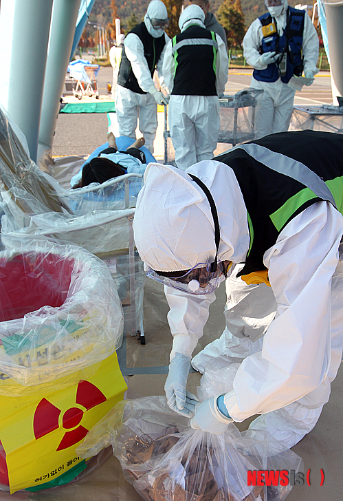 【울산=뉴시스】유재형 기자 = 2014 고리 방사능방재 연합훈련이 20일 고리원자력발전소 일원에서 열렸다. 주민 구호소에서 환자의 의복에 방사선 노출로 인해 의복을 폐기하고 있다.(사진=원자력안전위원회 제공).2014.11.20.&nbsp; photo@newsis.com