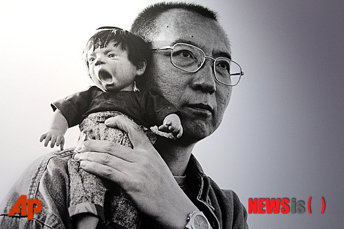 【워싱턴=AP/뉴시스】미국 정부가 중국의 대표적 반체제 인사이자 노벨 평화상 수상자인 류샤오보(劉曉波)의 석방을 촉구한 가운데 중국이 "미국은 타국의 재판관을 자처하지 말라"고 반박하면서 비난했다. 존 케리 미 국무장관은 지난 24일 특별성명을 통해 "류샤오보가 정권정복 기도 죄로 수감된 지 오늘로 꼭 5년이 됐다"면서 "중국 정부가 아직 류샤오보를 구금하고 그의 부인인 류샤(劉霞)를 가택연금하고 있는데 대해 깊은 우려를 표명한다"고 밝혔다. 지난 2012년 2월17일 AP 자료사진으로, 수감 중인 류샤오보가 인형을 어깨에 대고 있는 모습. 2014.12.26