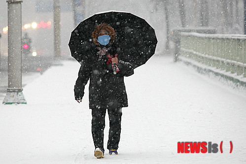 【춘천=뉴시스】예상철 기자 = 15일 오후 강원 춘천시에 대설주의보가 발령 가운데 한 시민이 눈을 피해 발걸음을 재촉하고 있다. 2014.12.15. yesc@newsis.com