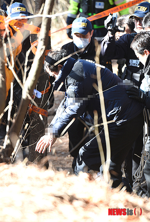 【수원=뉴시스】강종민 기자 = 17일 오후 경기 수원 팔달산 토막살인 피의자 박춘봉 (55·중국국적) 이 피해자 시신 일부를 매장한 수원 팔달산 등산로에서 현장검증을 하고 있다. 2014.12.17&nbsp; ppkjm@newsis.com 