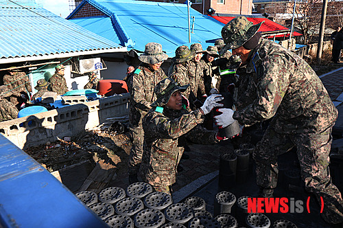 【고성(강원)=뉴시스】김경목 기자 = 육군 제22보병사단 공병대대 장병들이 17일 강원 고성군 공현진에서 저소득층 가정에 사랑의 연탄을 배달하느라 구슬땀을 흘리고 있다. 고성군연탄후원회, 적십자사 등과 함께 했다. 2014.12.17. (사진=육군 제22보병사단 제공) photo@newsis.com