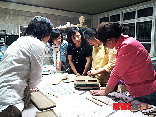 【영동=뉴시스】김기준 기자 = 충북 영동군 용산면 부상리 옛 부상초등학교에 둥지를 튼 도예공방 '토사랑'(대표 신효정·40)의 도자기 체험 프로그램이 인기다. 토사랑에 따르면 매년 1만여 명의 관람객이 이곳을 방문했고, 이 가운데 4000~5000명이 도자기 체험 행사를 즐겼다. 사진은 지난 9월 '토사랑'에서 도자기 체험을 하는 사람들의 모습이다.2014.12.22.(사진=영동군청 제공)&nbsp; photo@newsis.com 