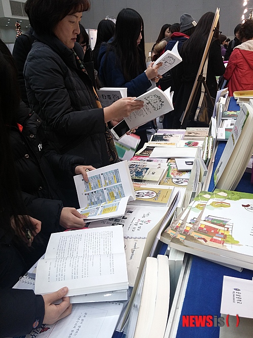 【진도=뉴시스】송창헌 기자 = 지난 19일 교육부 주최로 대구에서 열린 '2014 전국 책축제'를 찾은 시민과 학생들이 전남 진도고등학교 인문학 책쓰기 동아리 소속 학생들이 직접 펴낸 인문학 총서인 '진도비전(珍島秘傳)'을 읽고 있다. 2014.12.23 (사진=진도고 제공)&nbsp; goodchang@newsis.com