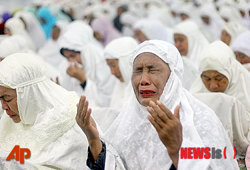 【반다아체=AP/뉴시스】인도네시아 여성들이 25일 아체주(州) 반다아체에 있는 바이툴라만 사원에서 인도양 쓰나미 참사 발생 10주년 기도회에서 희생자들을 추모하며 울고 있다. 지난 2004년 12월26일 아체주 해안에서 발생한 리히터 규모 9.1의 강진으로 쓰나미가 발생해 아시아 곳곳에서 23만명이 숨졌다. 2014.12.26