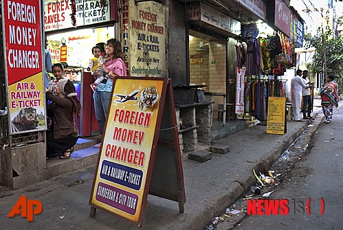 【콜카타=AP/뉴시스】외국인 관광객들이 4일(현지시간) 인도 콜카타시 수데르 거리에 있는 환전소에서 환전하기 위해 기다리고 있다. 이 도시는 외국인 배낭족 사이에서 유명한 관광지다. 현지 경찰은 이날 남성 5명을 일본인 교환 학생으로 인도를 관광하던 22세 여성을 성폭행한 혐의로 체포했다고 밝혔다. 피해여성은 지난 11월 불교 수데르 거리에 있는 불교성지순례 인근 호텔에 머물며 여행하다 이 같은 변을 당한 것으로 알려졌다. 2015.01.05