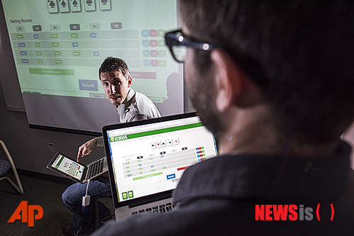 【뉴욕=AP/뉴시스】캐나다 앨버타대학이 제공한 사진으로 이 대학의 마이클 보울링 교수(왼쪽)와 그의 연구진 마이클 존슨이 포커 게임 컴퓨터 프로그램을 시연하고 있다. 보울링 교수가 8일(현지시간) 과학 전문 사이언스에 컴퓨터가 포커 게임 방법을 스스로 익혀 한 게임에서 인간을 상대로 이길 수 있는 최고의 전략을 세우는 프로그램을 개발했다고 밝혔다. 2015.01.10