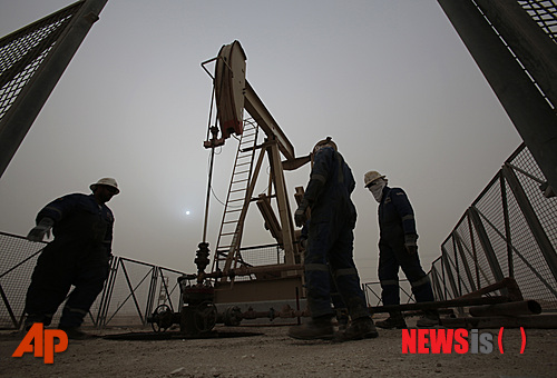 【사키르(바레인)=AP/뉴시스】연일 하락하는 국제 유가가 13일(현지시간) 45달러 선으로 떨어져 6년래 최저치를 기록했다. 유가 하락으로 석유수출국기구(OPEC) 회원국 간 갈등이 확산되고 있다. 사우디아라비아와 쿠웨이트가 감산에 나서지 않고 아랍에미리트(UAE)가 증산 계획을 유지하면서 감산을 선호하는 이란과 베네수엘라의 불만이 커지고 있다. 지난 8일 바레인 사키르 사막에 있는 유전에서 노동자들이 작업을 하는 모습. 2015.01.14 