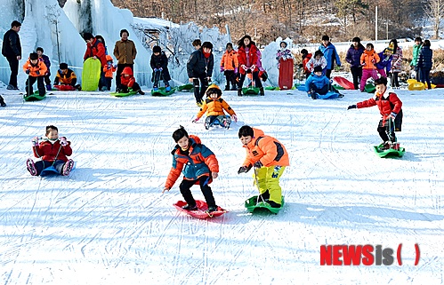 【증평=뉴시스】강신욱 기자 = 20일 충북 증평군이 증평읍 남하리 증평민속체험박물관 앞에 조성한 눈썰매장에서 가족과 함께 온 청소년들이 눈썰매를 즐기고 있다. 2015.01.20. (사진=증평군 제공)&nbsp;&nbsp; photo@newsis.com