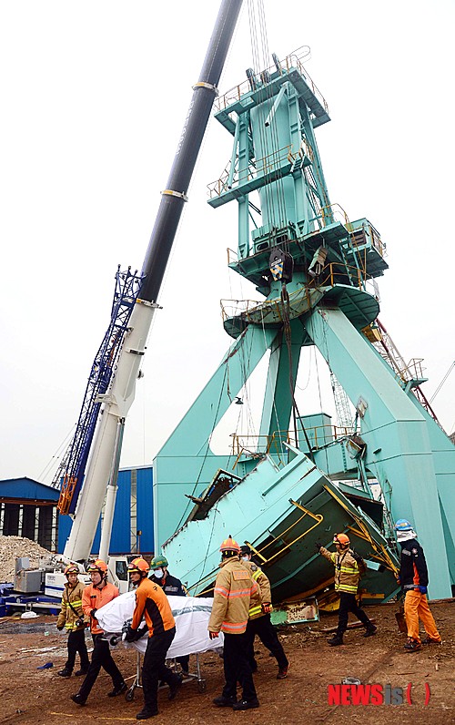 【부산=뉴시스】 하경민 기자= 21일 오전 9시 46분께 부산 영도구 청학동의 한 선박 건조·수리 조선소에서 높이 12m인 40t급 크레인의 무게 중심을 잡는 평형추(윈치) 부분이 떨어졌다.&nbsp; 이 사고로 크레인 해체작업을 하던 근로자 4명이 추락한 구조물에 깔려 숨졌다.&nbsp; 사진은 구조물에 깔린 사망자를 수습하는 모습. 2015.01.21.&nbsp; yulnetphoto@newsis.com 
