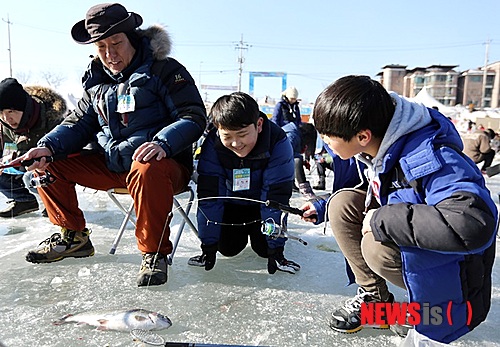 가평군 자라섬씽씽겨울축제장을 찾아 송어낚시를 즐기고 있는 가족.