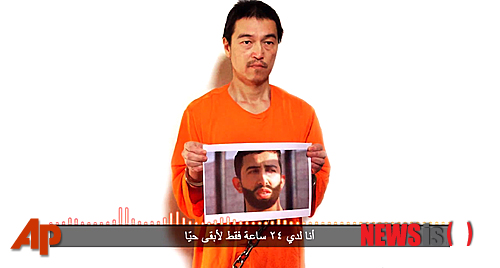 【AP/뉴시스】이슬람 무장단체 '이슬람국가(IS)'가 27일(현지시간) 24시간 내 자신들이 원하는 여성 테러범을 석방하지 않으면 일본인 인질과 요르단 조종사를 살해하겠다고 시한을 제시해 위기감이 고조되고 있다. IS는 최후 경고 메시지라면서 유튜브에 영상을 공개했다. IS에 억류 중인 일본인 인질 고토 겐지(後藤健二·47)가 요르단 조종사 모아즈 알 카사스베 중위의 사진을 들고 서 있는 모습. 2015.01.28 